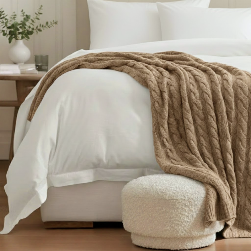 Cashmere cable knit throw in oatmeal on bed